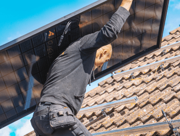 Man op dak installeert soloya zonnepanelen